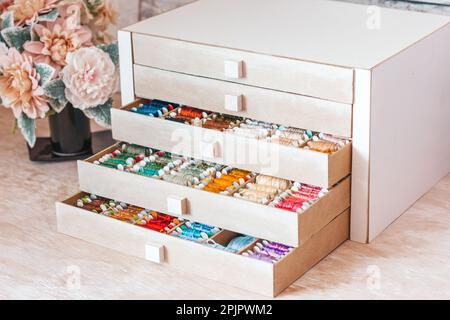 Beautiful box for threads with compartments. Beautiful colored threads in a box Stock Photo