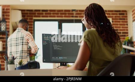 Female programmer using code to develop online app, working with html script on terminal window to program database software. IT manager planning artificial intelligence network. Handheld shot. Stock Photo