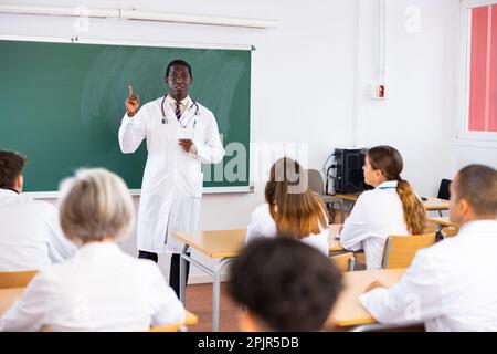 Professor talking to medical students in classroom Stock Photo