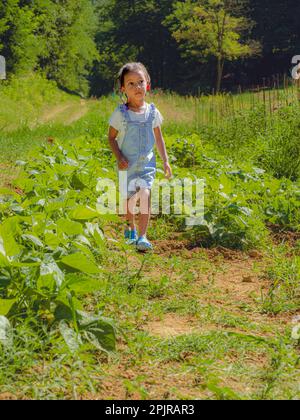 African little girl walking in the farm vegetable garden taking