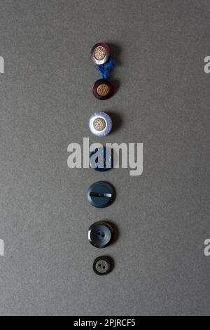 collection of buttons of various forms on blank grey cardboard Stock Photo
