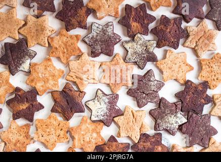 Assorted christmas ginger cookies over white wooden table. Christmas cooking background. Six pointed star cookies Stock Photo