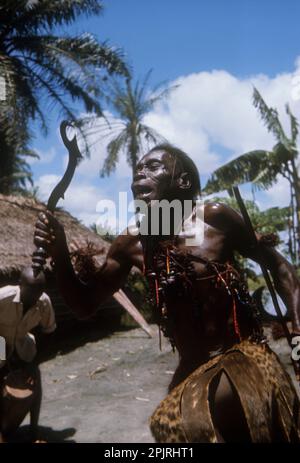 Africa, Democratic Republic of the Congo, Ngiri River area. Libinza ethnic group. Diviner dancing, holding ceremonial knife. Stock Photo