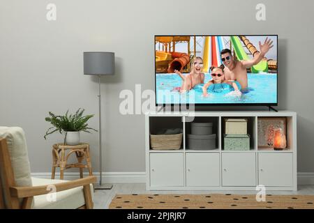 Modern TV set on wooden stand in room Stock Photo