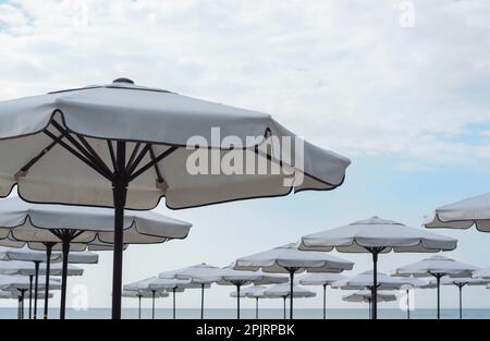 Beautiful white beach umbrellas against blue sky Stock Photo