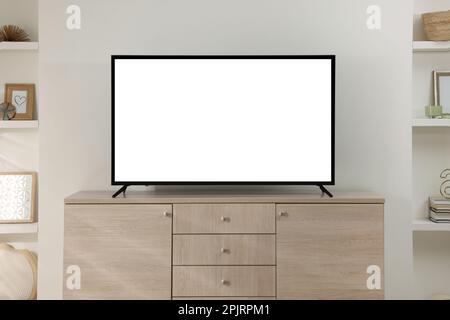 Modern TV set on wooden cabinet in room Stock Photo