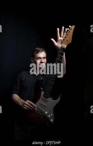 Young male guitarist playing with electric guitar Stock Photo
