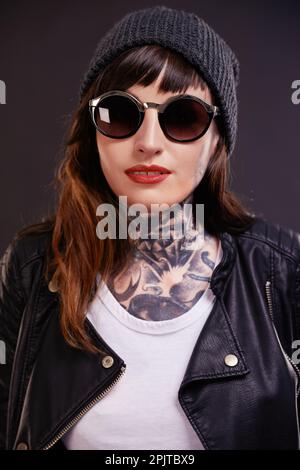 Tattooed with an attitude. A cropped studio portrait of a tattooed young woman. Stock Photo