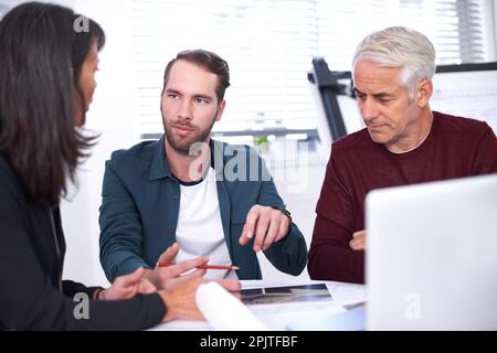 Discussing ideas for the new project. three architects working on a new building design. Stock Photo