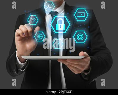 Cyber security concept. Closeup view of man with tablet and different virtual icons on grey background, illustration Stock Photo