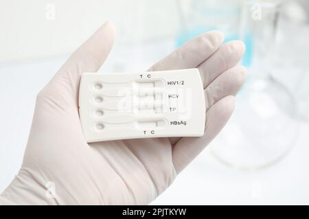 Doctor holding disposable express test for hepatitis indoors, closeup Stock Photo