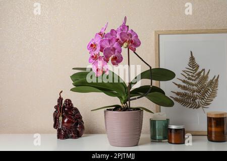 Beautiful pink orchid flower and different decor elements on white table Stock Photo