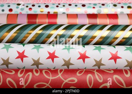 Different colorful wrapping paper rolls as background, closeup Stock Photo