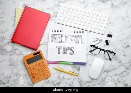 Flat lay composition with text Helpful Tips in notebook on white marble table Stock Photo