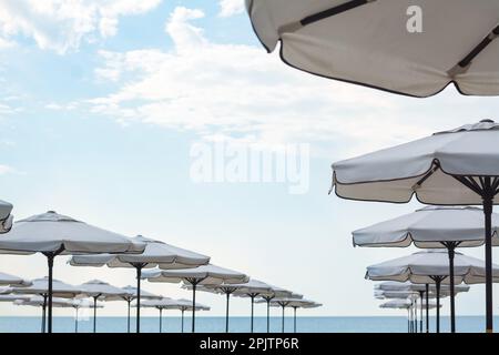 Beautiful white beach umbrellas against blue sky Stock Photo