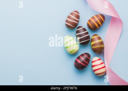 Chocolate easter eggs on the blue background. Top view. Stock Photo