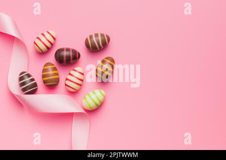 Chocolate easter eggs on the pink background. Top view. Stock Photo