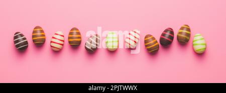 Chocolate easter eggs on the pink background. Top view. Stock Photo