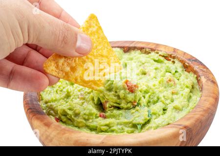 Dipping corn chips into guacamole on white background. Stock Photo
