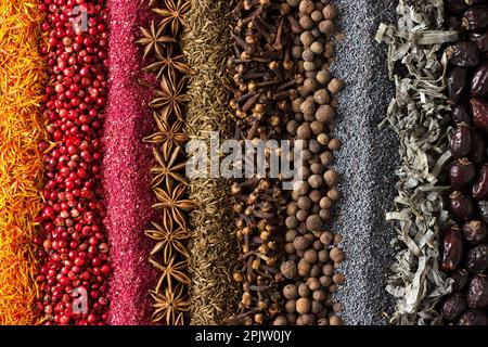 Spices and herbs background for website design. Seasonings scattered on the table. Stock Photo