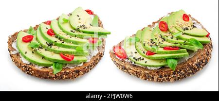 Avocado toasts - bread with avocado slices, pieces of chilli pepper and black sesame isolated on white background. Stock Photo