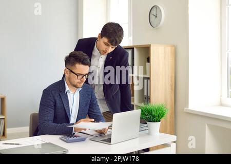 Two employees working in the company office and doing business paperwork together Stock Photo
