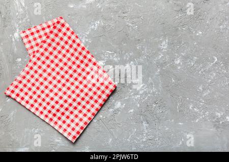 top view with red empty kitchen napkin isolated on table background. Folded cloth for mockup with copy space, Flat lay. Minimal style. Stock Photo