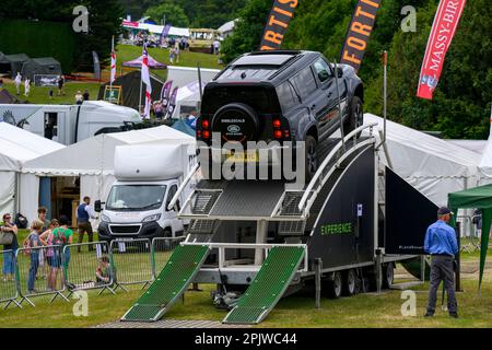 Defender drives up ascent (challenging temporary showground course) & visitors - L R Experience, Great Yorkshire Show 2022, Harrogate, England, UK. Stock Photo