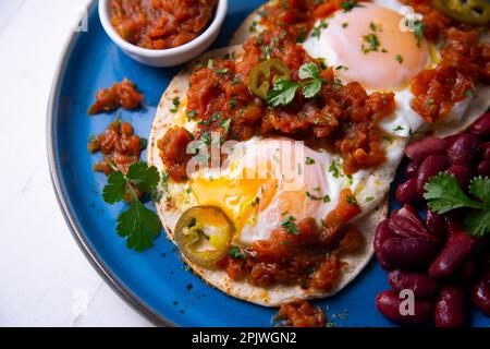 Huevos rancheros are a traditional Mexican breakfast, which basically consists of: fried eggs on corn tortillas with a sauce made from tomatoes, Stock Photo