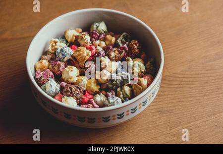 Multicolored kettle popcorn on wooden background. Soft focus Stock Photo