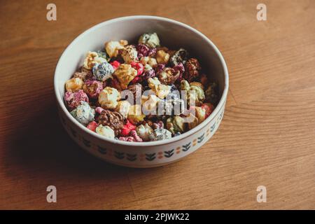 Multicolored kettle popcorn on wooden background. Soft focus Stock Photo