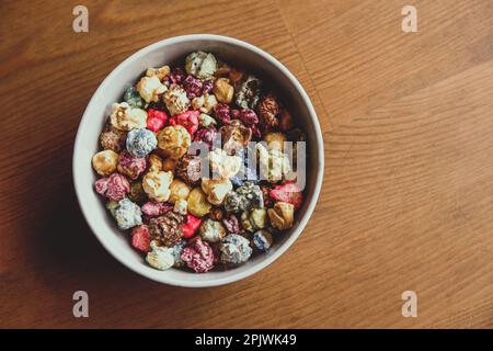 Multicolored kettle popcorn on wooden background. Soft focus Stock Photo