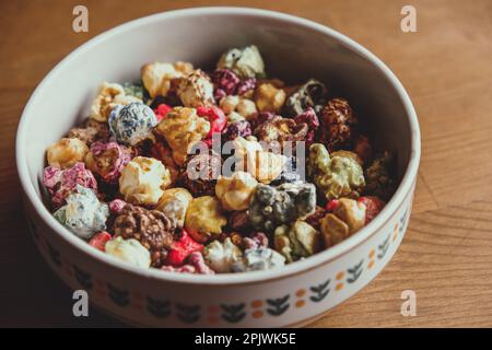 Multicolored kettle popcorn on wooden background. Soft focus Stock Photo