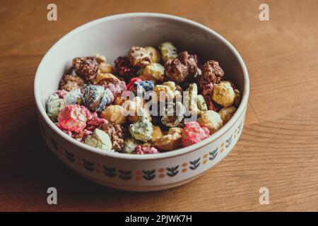 Multicolored kettle popcorn on wooden background. Soft focus Stock Photo