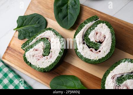 Spinach tortilla roll stuffed with ham and cream cheese. Stock Photo