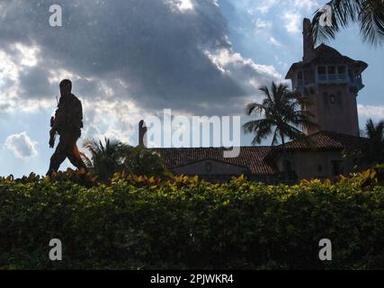 Armed Secret Service agent guards the perimeter of Mar-a-Lago. Former President Donald Trump arrives at Palm Beach International Airport as supporters Stock Photo
