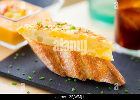 Potato omelette tapa. A small slice of bread on which a small portion of food is placed is called a skewer. Stock Photo