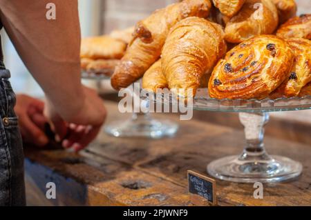 French traditional pastries on a glass tray. Pains aux raisins and croissants. Selective focus. Stock Photo