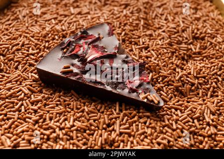 Chocolate background. A piece of chocolate pizza lies in a chocolate crumb close-up. The concept of confectionery. Stock Photo