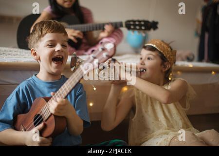 Happy three friends playing on a musical instuments. Stock Photo