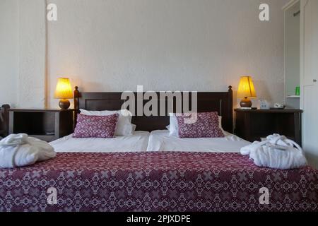 Retro style bedroom with red pattern pillows on bed Stock Photo