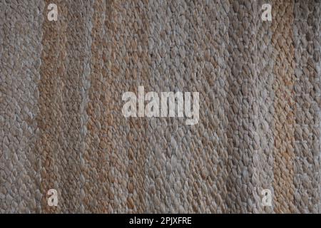 Woven jute rug, modern natural braided jute living area rug design. Wicker carpet concept idea photo. Eco-friendly interior detail in home. Stock Photo