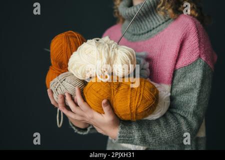 Close-up view of woman's hands holding colored skeins of wool yarn. Creative concept of knitting. Handmade hobby stay home concept. Craft and DIY Stock Photo