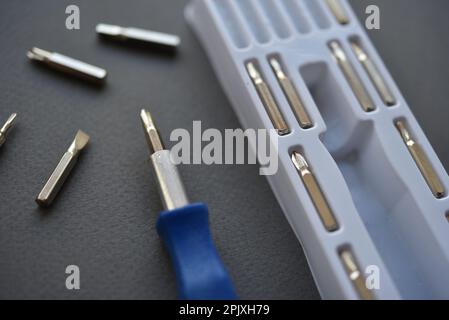 A set of screwdrivers with nozzles on a gray background. Replaceable nozzles for a screwdriver. Stock Photo