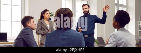 Multiethnic people man and woman watch manager presentation in office with large windows Stock Photo