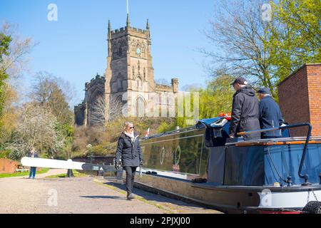 Kidderminster, UK. 4th April, 2023. UK weather: plenty of spring sunshine and blue skies makes for a perfect day on the water. A family and friends are all aboard their canal boat as they pass through a lock with St Mary's Church in Kidderminster in the background. Credit: Lee Hudson/Alamy Live News Stock Photo
