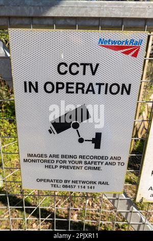Network Rail warning signs fixed to a metal fence alongside a railway line Norfolk England UK Stock Photo