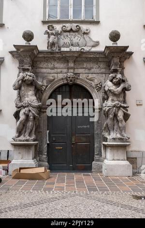 Slovenia, Ljubljana, Portal of Ljubljana Theological Seminary Palace Library, entrance with two sculptures of Atlas flanking the doorway. Portal work Stock Photo