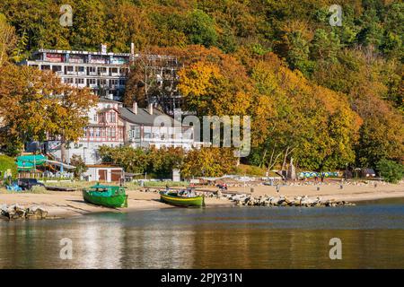 Gdynia Orłowo in northern Poland, Pomerania region. View from the Baltic Sea to the beach and autumn foliage on a hillside with abandoned sanatorium. Stock Photo