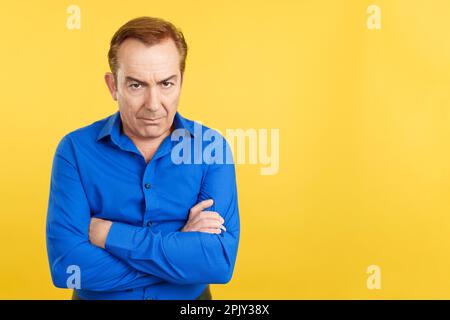 Mature man crossing the arms with an angry expression Stock Photo